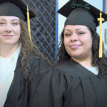 Two graduates pose for the camera